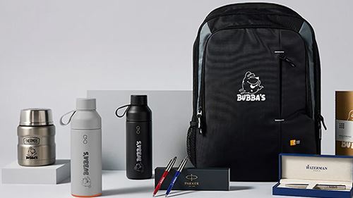 Variety of promotional items including backpacks, tumblers, pens, and notebooks with logos